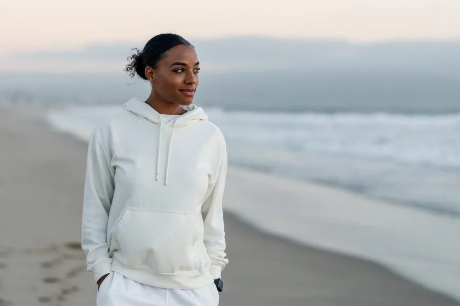 young african american woman looking out into the ocean thinking